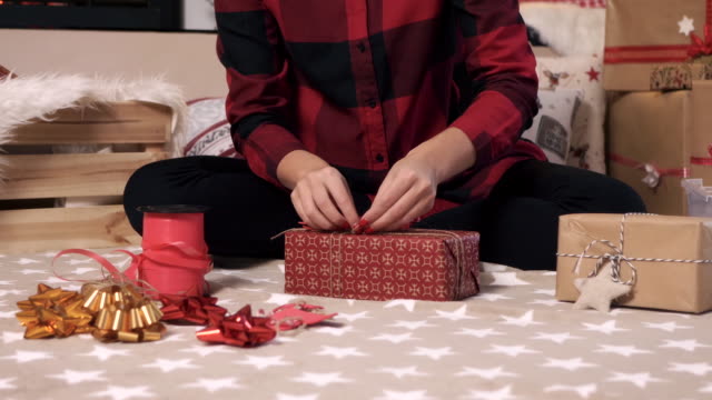 Woman-making-christmas-present-at-living-room