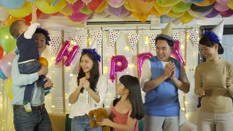 Group-of-young-asian-family-dancing-together-in-party-event-at-home.-Happy-family-celebrating-New-Year's-Eve.