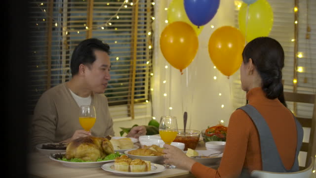 Familia-de-tostado-en-la-cena-de-Navidad.-Feliz-familia-asiática-disfrutando-de-una-cena-de-Navidad-juntos-en-casa.