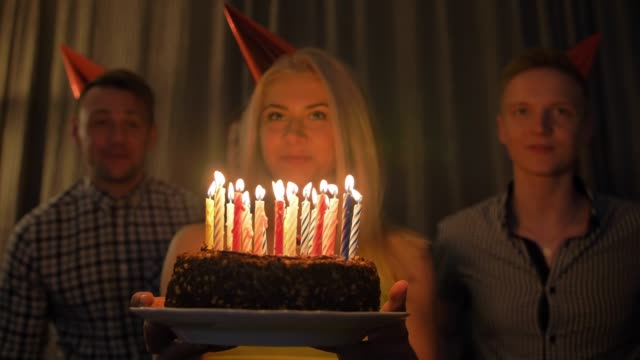Schöne-Frau-Aktien-Geburtstagsfeier-mit-Freunden-gesammelt-Ausblasen-der-Kerzen-auf-Kuchen
