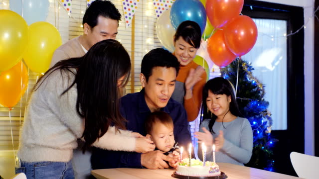 Little-boy-blows-out-candles-on-birthday-cake-at-party-with-happy-emotion.-People-with-party-and-celebration-concept.-4K-Resolution.