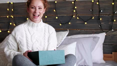 Happy-girl-opening-christmas-gifts-in-bed