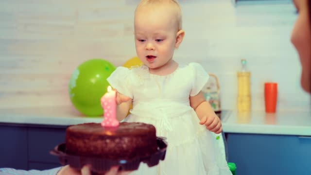Bebé-está-tratando-de-soplar-la-vela-en-el-pastel-de-cumpleaños