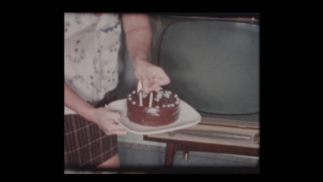 1961-2-jährige-bläst-junge-Kerzen-auf-Geburtstagskuchen
