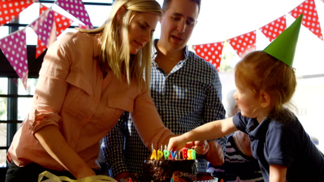 Mother-and-son-decorating-birthday-cake-at-home-4k