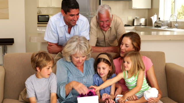 Grandmother-getting-presents-from-her-grandchildren-on-couch
