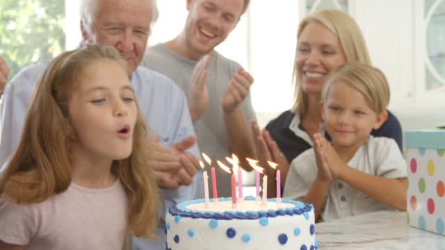 Girl-Blows-Out-Candles-On-Birthday-Cake,-Slow-Motion