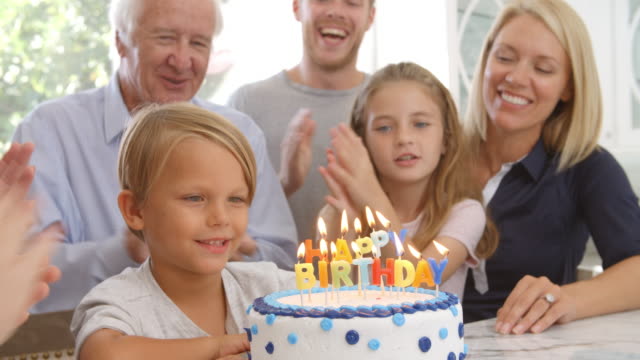 Boy-Blows-Out-Candles-On-Birthday-Cake,-Slow-Motion