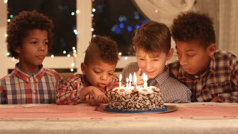 Kinder-in-der-Nähe-von-Kuchen-mit-Kerzen.