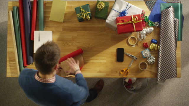 Top-View-of-Young-Man-Skillfully-Packing-Colorful-Gifts.-All-Happening-in-Fast-Motion.