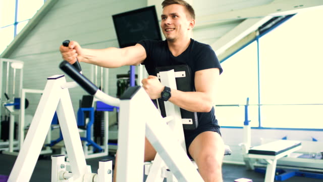 Schön-sportlicher-Mann-trainiert-und-lächelt-im-Fitness-Club-und-Fitnessstudio