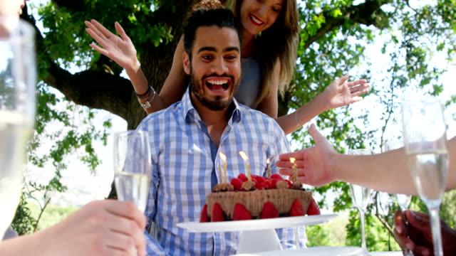 Amigos-celebrando-mans-cumpleaños-en-el-restaurante-al-aire-libre