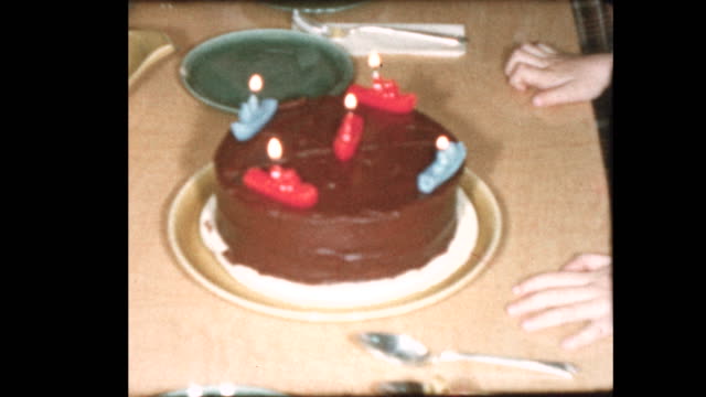 5-año-de-edad-sopla-velas-de-cumpleaños-y-familiar-canta