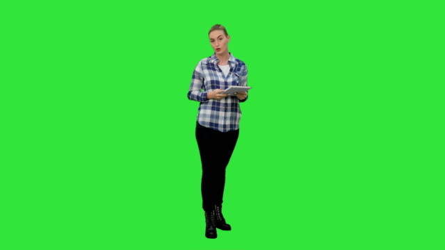 Young-woman-using-reading-presentation-from-a-tablet-on-a-Green-Screen,-Chroma-Key