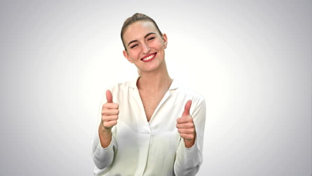 Glücklich-erregte-Frau-zeigen-Genehmigung-Hand-Geste-Daumen-und-lächelnd-auf-weißem-Hintergrund