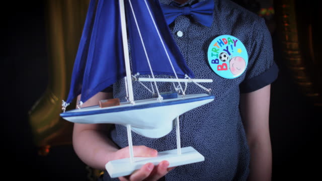 4K-Party-10-Geburtstagskind-halten-vorhanden-Spielzeugboot
