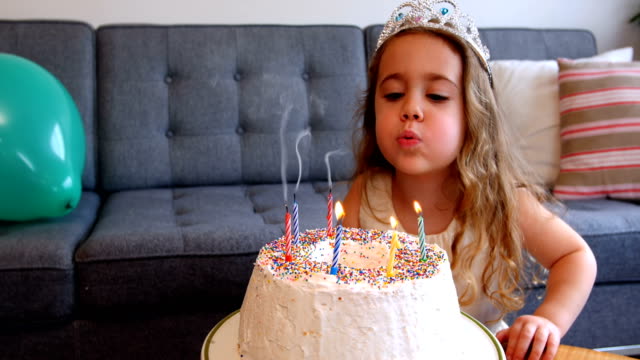 Soplar-velas-en-la-tarta-de-cumpleaños-niña