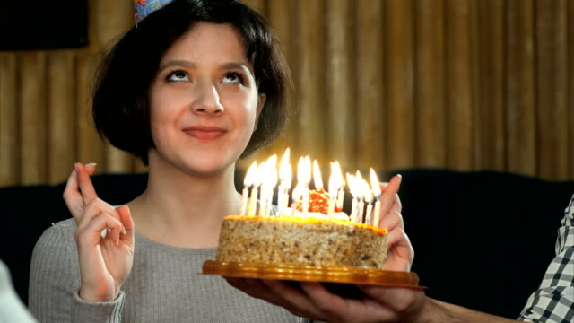 Junge-Mädchen-Blasen-Kerzen-auf-Geburtstagskuchen