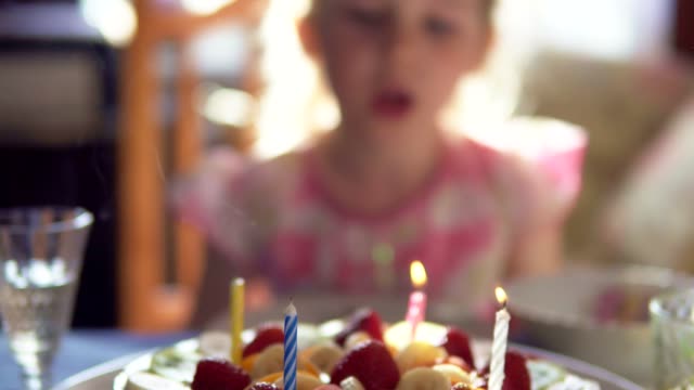 Kleines-Mädchen-bläst-Kerzen-auf-Geburtstagskuchen-und-Claping-aus-ihren-Händen