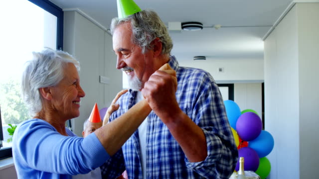 Senior-pareja-con-sombreros-de-fiesta-bailando-en-el-cumpleaños-del-partido-4k
