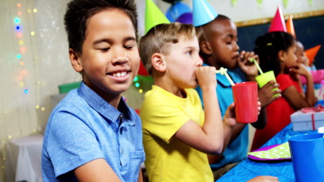 Portrait-of-boy-sitting-with-friends-during-birthday-party-4k