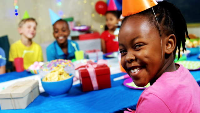Portrait-of-smiling-girl-sitting-with-friends-at-table-during-birthday-party-4k