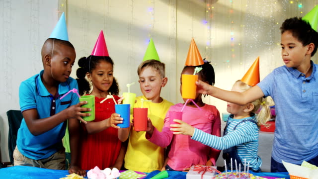 Glückliche-Kinder-Toasten-Getränke-während-Geburtstag-party-4k