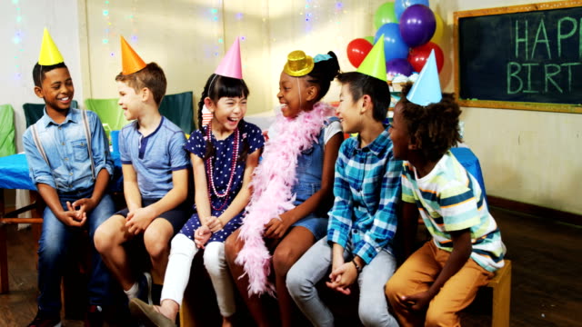 Kinder-Lächeln-während-der-Sitzung-zusammen-während-der-Geburtstagsfeier-4k