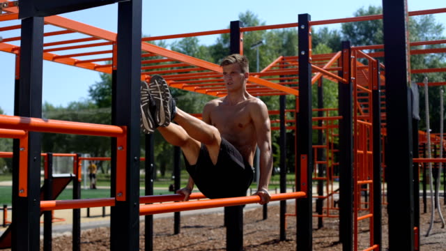 Topless-athlete-performing-abdominal-exercises-on-the-parallel-bars.-50-fps
