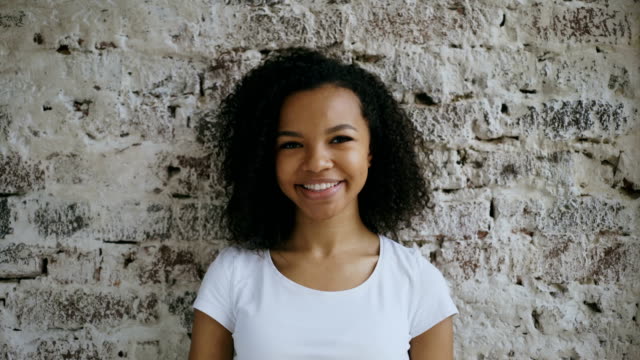 Porträt-von-geschweiften-afroamerikanischen-Mädchen-präsent-Geschenk-Box-und-Lächeln-in-die-Kamera