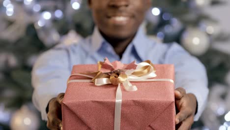 Schwarzer-Mann-präsentiert-eine-Geschenkbox