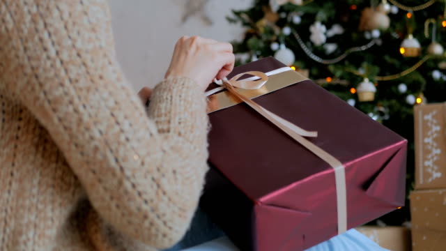 Frau-wickelt-Band-auf-Weihnachten-Geschenk-box