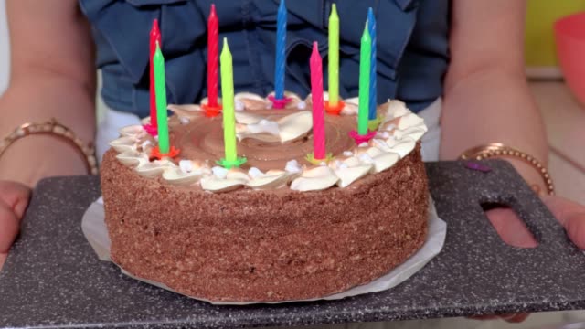 Woman-with-birthday-cake-at-home-in-kitchen