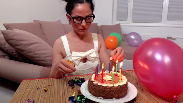 Woman-near-birthday-party-cake-with-burning-candles