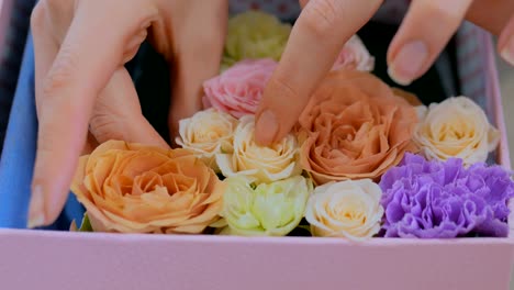 Professional-florist-making-gift-box-with-flowers-at-flower-store