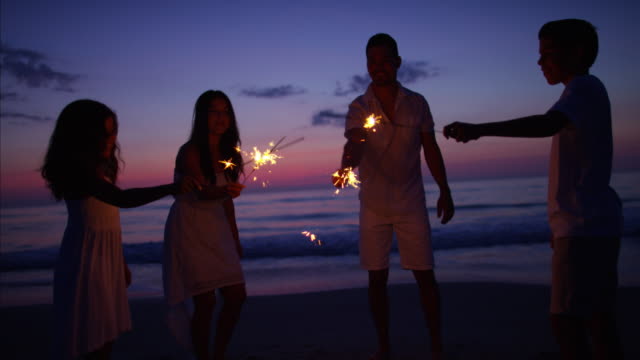Spanish-family-celebrating-birthday-with-sparklers-at-sunset