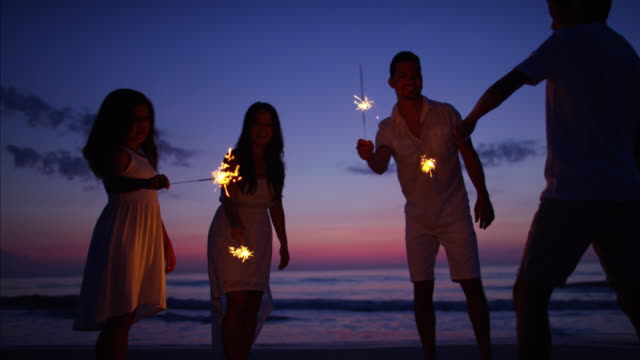 Hispanic-family-celebrating-birthday-with-sparklers-at-sunset