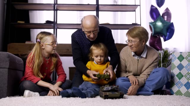 Granfather-teaching-boy-to-use-radio-control-toy