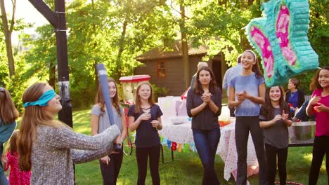 Freunde-sehen-ein-junges-Mädchen-trifft-eine-Piñata-zum-Geburtstag