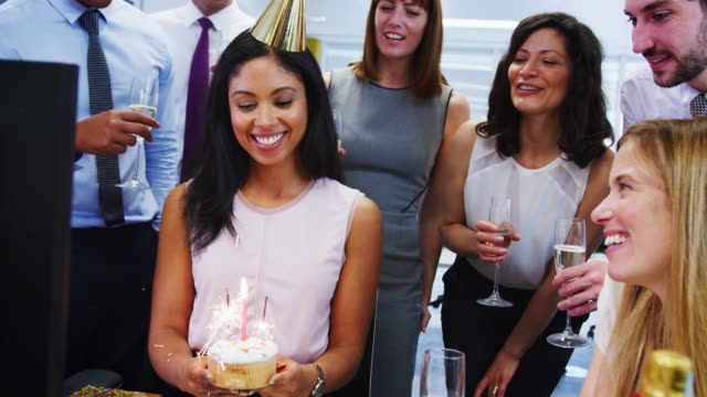Colleagues-gather-at-womanÕs-desk-to-celebrate-her-birthday