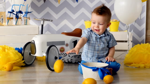 Das-Kind-spielt-mit-hellen-gelben-Zitronen-auf-dem-Boden.
