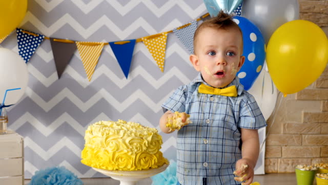 El-comer-de-la-torta-de-cumpleaños-hermoso-amarillo-con-las-manos.