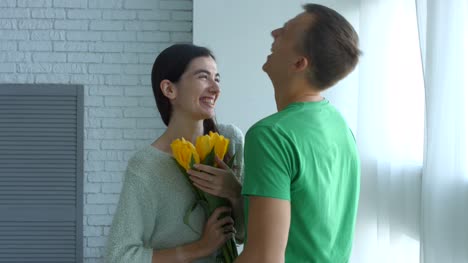 Excited-woman-surprised-by-bunch-of-flowers-from-man