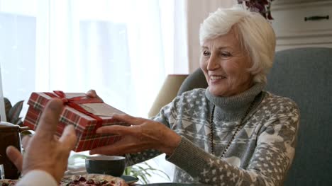 Anciana-recibir-regalo-y-tarjeta-de-felicitación-en-la-cena