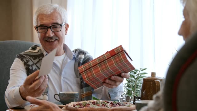 Senior-Man-Receiving-Gift-at-Dinner-in-Restaurant