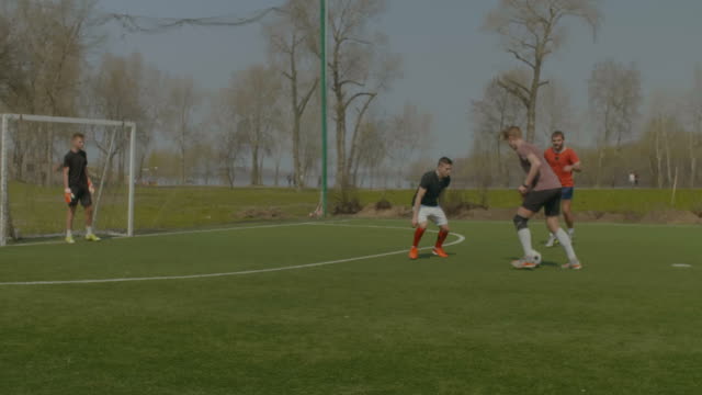 Deportivos-jóvenes-jugando-fútbol-en-el-campo-de