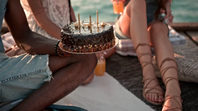 Amigos-multiétnicas-que-cumpleaños-fiesta-con-torta-en-embarcadero