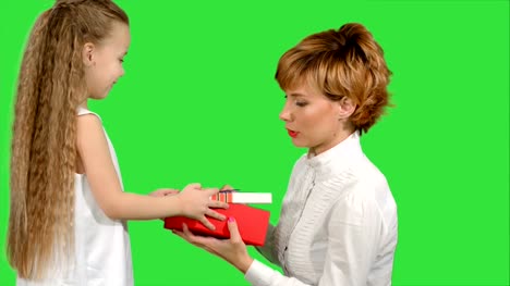 Pretty-caucasian-woman-getting-chrismas-gift-from-her-daughter-on-a-Green-Screen,-Chroma-Key