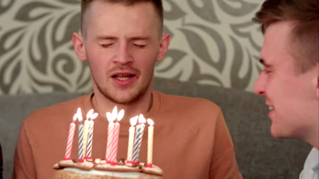 Hübscher-Junge-Dreamsabout-seine-Wünsche-und-bläst-Kerzen-auf-Geburtstagskuchen-und-Getränke-orange-saft