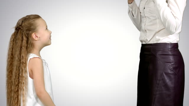 Kleines-Mädchen-zu-ihrer-Mutter-ein-Geschenk-zu-geben-und-küssen-auf-weißem-Hintergrund